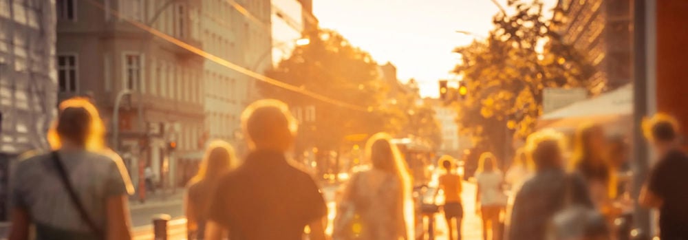 People walking down a city street in the sun