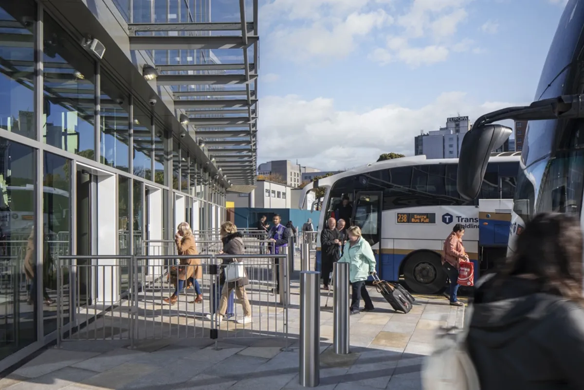 Bus passengers entering Belfast Grand Central Station on clear day