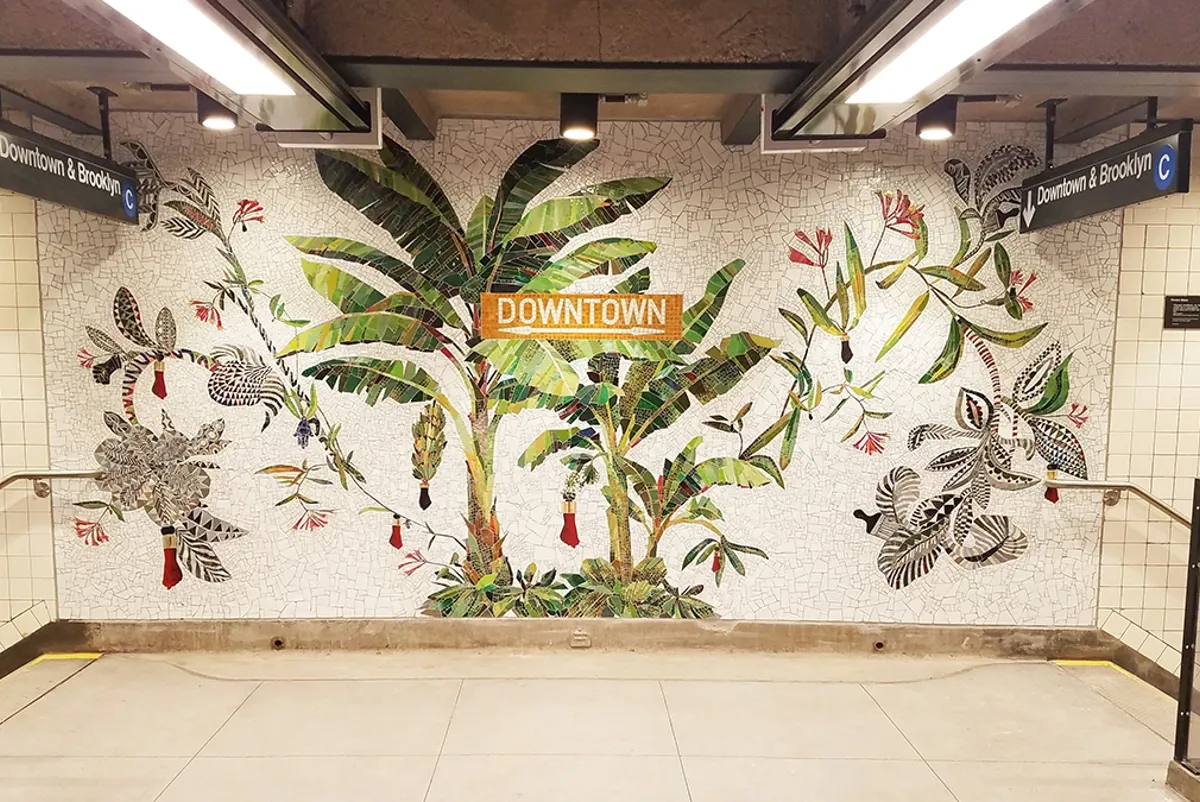 Interior of New York City subway station with tiled art of palm trees