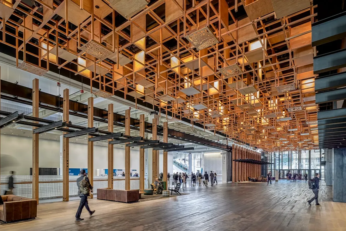 A large room with people and a large ceiling with many windows.